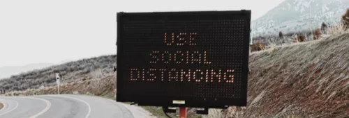 Road sign displaying social distancing