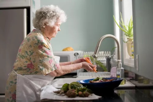 Elderly woman washing carrots