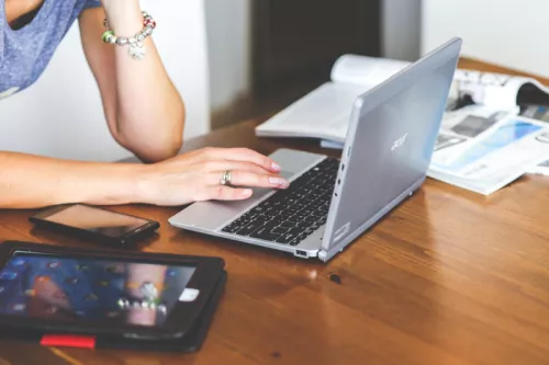 Woman with laptop phone and books