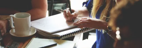 A Group Of People Around A Table And Pc