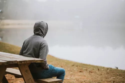 Man sitting on bench by lake