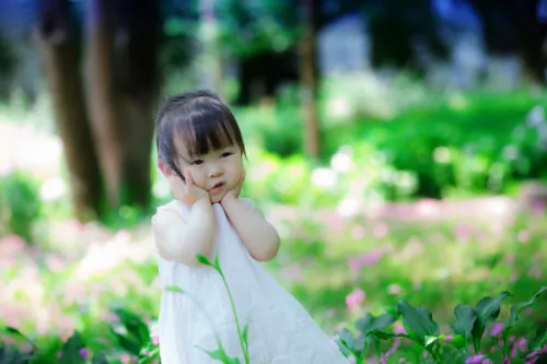 Little girl in white dress in garden