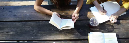People reading at wooden bench