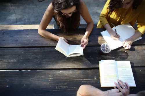 People reading at wooden bench