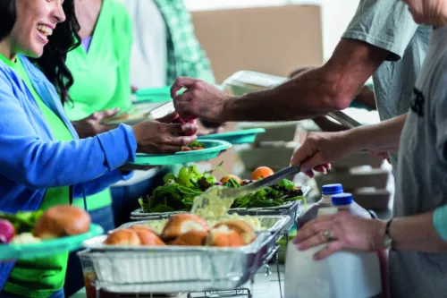 Woman receives a healthy meal at soup kitchen stock photo