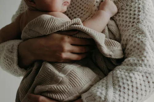 A lady holding a baby in a blanket