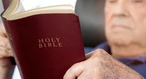 Old man reading Bible blur