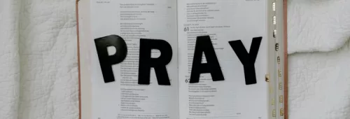 The word pray on an open bible